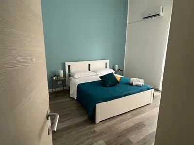 a small bedroom with a bed with blue walls at Quintino Sella 41 Apartment in Palermo