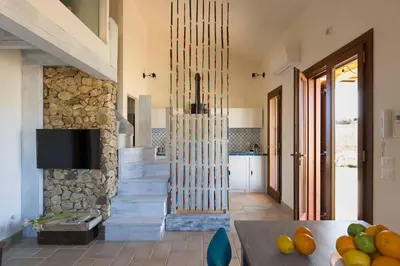 a kitchen with a stone staircase with a tv at Villa Guidaloca Cala Bianca in Castellammare del Golfo