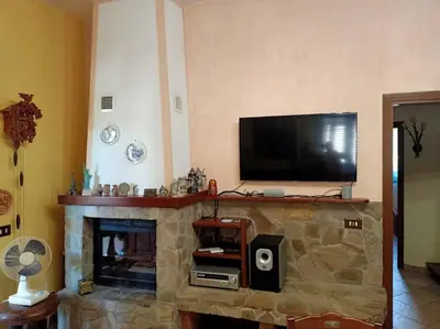 a living room with a fireplace with a flat screen tv at Il giardino degli ulivi in Trabia