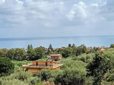 a house in the middle of a field with trees at Il giardino degli ulivi in Trabia