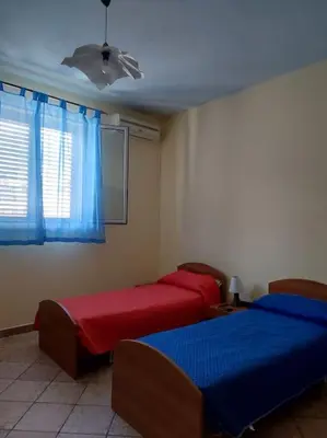 two beds in a room with blue and red at Il giardino degli ulivi in Trabia