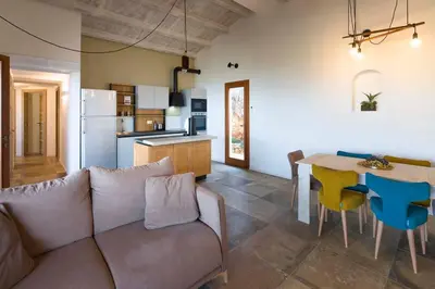 a living room with a couch and a table and a kitchen at Villa Scogliera Cala Bianca in Castellammare del Golfo