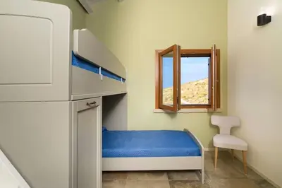 a small room with a bunk bed and a window at Villa Scogliera Cala Bianca in Castellammare del Golfo