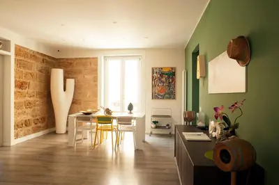 a living room with green walls and a table and chairs at B&B Cannoli in Palermo