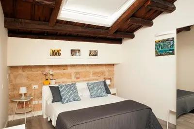 a bedroom with a bed and a brick wall at B&B Cannoli in Palermo