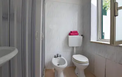 a white bathroom with a toilet and a sink at Gorgeous Apartment In Capaci With Wifi in Capaci