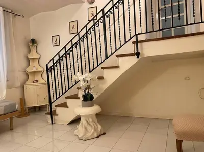 a living room with a staircase with a potted plant at The Tangerine's Garden in Palermo