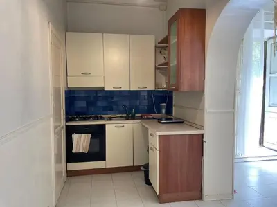 a kitchen with white cabinets and a stove at The Tangerine's Garden in Palermo