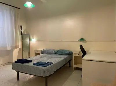 a small bedroom with a bed and a desk at The Tangerine's Garden in Palermo
