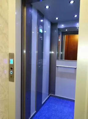 a elevator in a building with a blue floor and a mirror at Patania Royal Apartment in Palermo