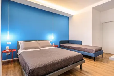 a bedroom with a bed and a blue wall at Merlo5 in Palermo