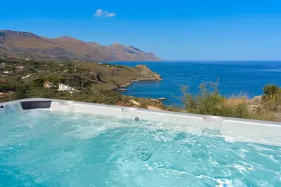 a hot tub with a view of the ocean at Villa Scopello Cala Bianca in Castellammare del Golfo