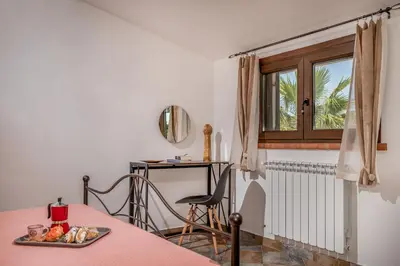 a room with a table and a desk with a window at Trinacrys - Casa Vacanze in Alcamo