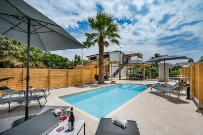 a swimming pool with two chairs and an umbrella at Trinacrys - Casa Vacanze in Alcamo