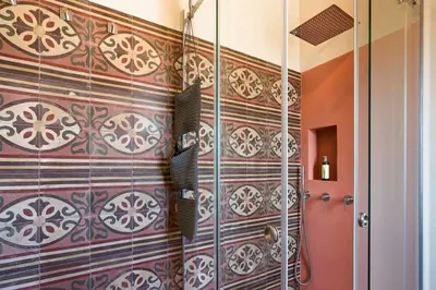 a bathroom with a shower with a tile wall at Villa Mori Cala Bianca in Castellammare del Golfo