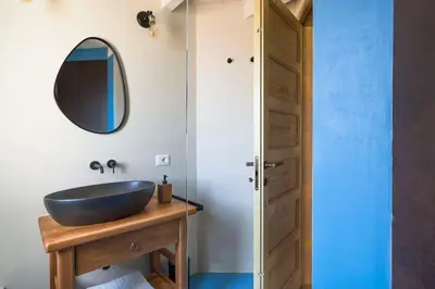 a bathroom with a blue sink and a mirror at Villa Mori Cala Bianca in Castellammare del Golfo