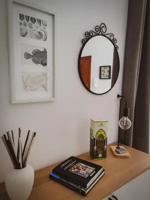 a desk with a mirror and a shelf with books at Casa Nicuzza alla Zisa in Palermo