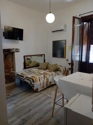a room with a bed and a table in it at Papireto house in Palermo