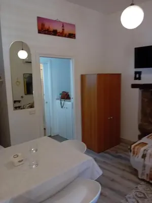 a room with a white table and a wooden cabinet at Papireto house in Palermo