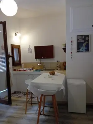 a kitchen with a table and a white table and chair at Papireto house in Palermo