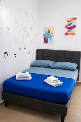 a bedroom with a blue bed with two towels on it at Giancos apartment in Palermo