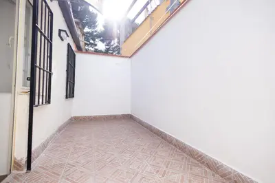 an empty hallway with white walls and tile floors at Giancos apartment in Palermo