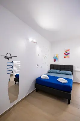 a bedroom with a blue bed in a white room at Giancos apartment in Palermo
