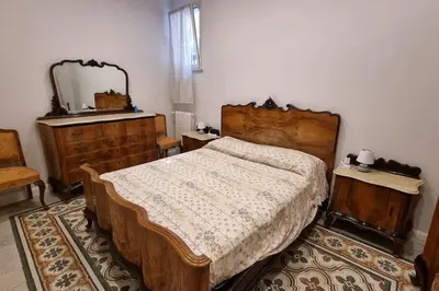 a bedroom with a bed and a dresser and a mirror at L'ùoro Apartment in Carini