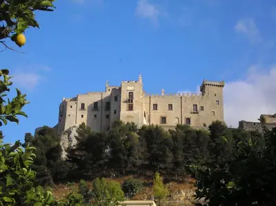 a castle on top of a hill with trees at L'ùoro Apartment in Carini