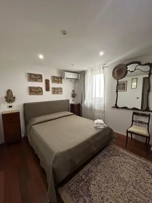 a bedroom with a large bed and a chair at Appartamento Palermo Sole di Sicilia in Palermo
