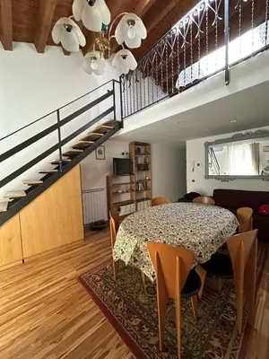 a dining room with a table and a staircase at Appartamento Palermo Sole di Sicilia in Palermo