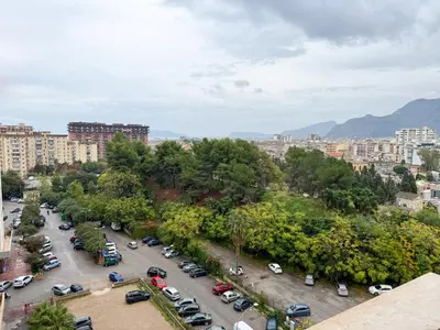 a city with cars parked in a parking lot at La Casetta di Ale - By Rental BeB Italy - in Palermo
