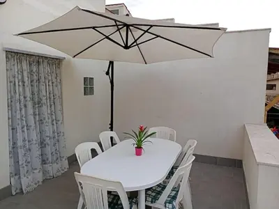 a white table with white chairs and an umbrella at Casa Agatea in Balestrate