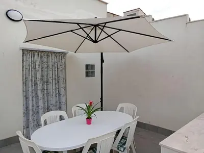 a white table with white chairs and a white umbrella at Casa Agatea in Balestrate
