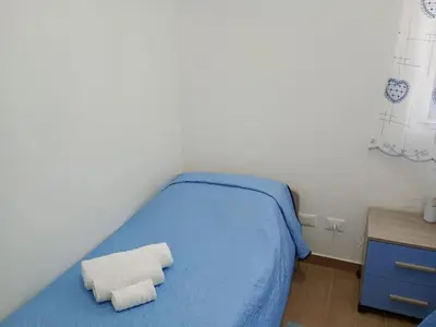 a bedroom with a blue bed with two towels on it at Casa Agatea in Balestrate