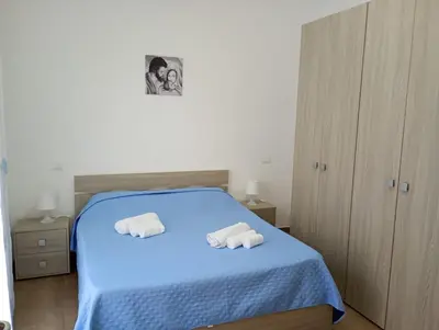 a bedroom with a blue bed with towels on it at Casa Agatea in Balestrate