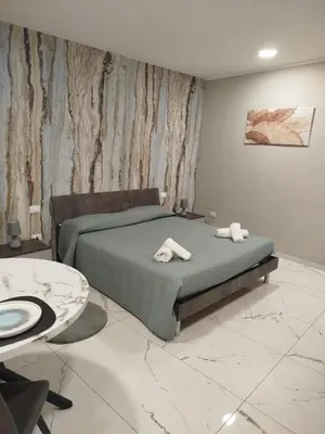 a bedroom with a bed and a television on the wall at Avusa Home in Palermo