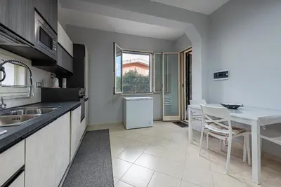 a kitchen with a sink and a table in it at Villino Giovanna a Trabia a 200 mt dal mare in Trabia