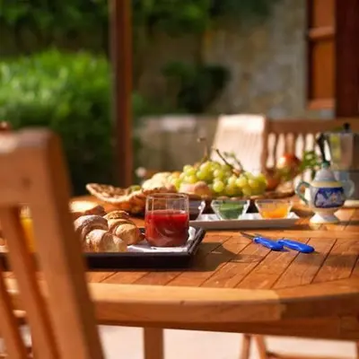 a wooden table with a plate of food on it at Villa Capreria by Sicily Travelling Villas in Scopello