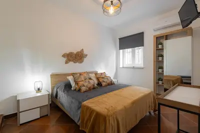 a bedroom with a bed in a white room at Maqueda Luxury Suite & Home in Palermo