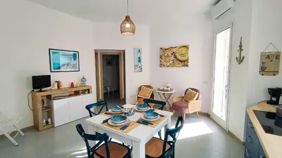 a dining room with a white table and chairs at Residence Spiaggia Centro - Aria Condizionata Wi-Fi&SelfCheck-In - Sole&Mare Home in Balestrate