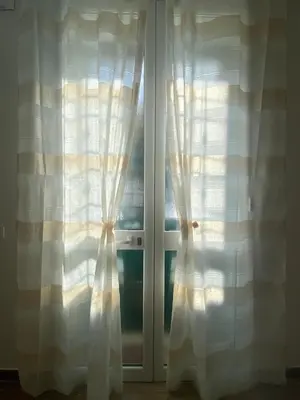 a window with white curtains in a room at Myrica House in Palermo