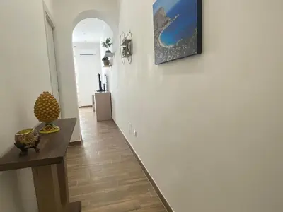 a hallway with a table and a painting on the wall at Myrica House in Palermo
