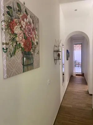 a hallway with a painting of flowers on the wall at Myrica House in Palermo