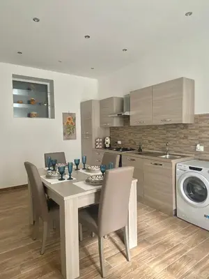 a kitchen with a table and chairs and a kitchen with a washing machine at Myrica House in Palermo