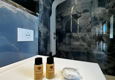 two bottles of essential oils sitting on a table in a bathroom at Alba Gold LUXURY SUITE & VILLA in Cefalù