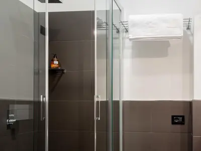 a shower with a glass door in a bathroom at Suite in Center Apartments in Palermo