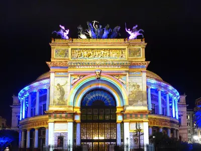 a building lit up in blue at night at Suite in Center Apartments in Palermo