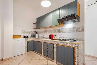 a kitchen with gray cabinets and a counter top at Villa Marinella by Sicily Travelling Villas in Scopello