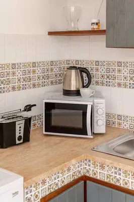 a kitchen counter with a microwave and a sink at Villa Marinella by Sicily Travelling Villas in Scopello